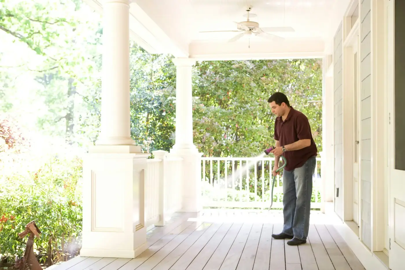 Technician spraying along the porch of a home
